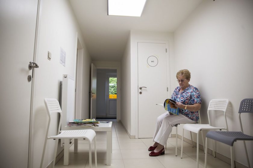 De wachtruimte met stoelen en een tafeltje met tijdschriften.
