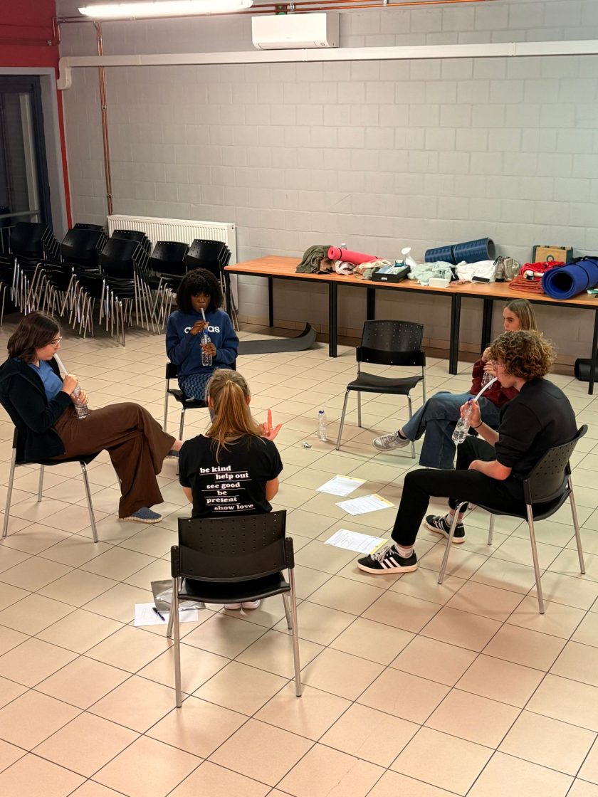 Een workshop stemgebruik: een groep staat in een kring te oefenen.